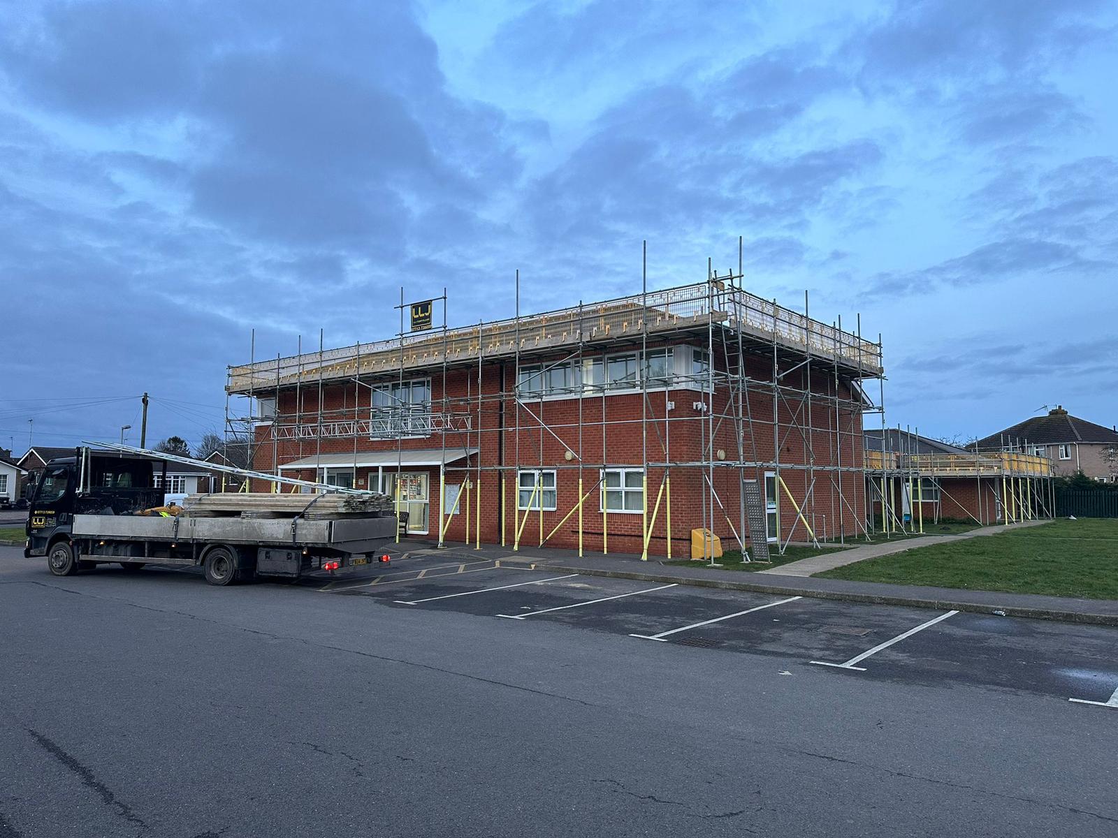 Commercial solar installation progress on Swineshead Medical Group exterior with scaffolding