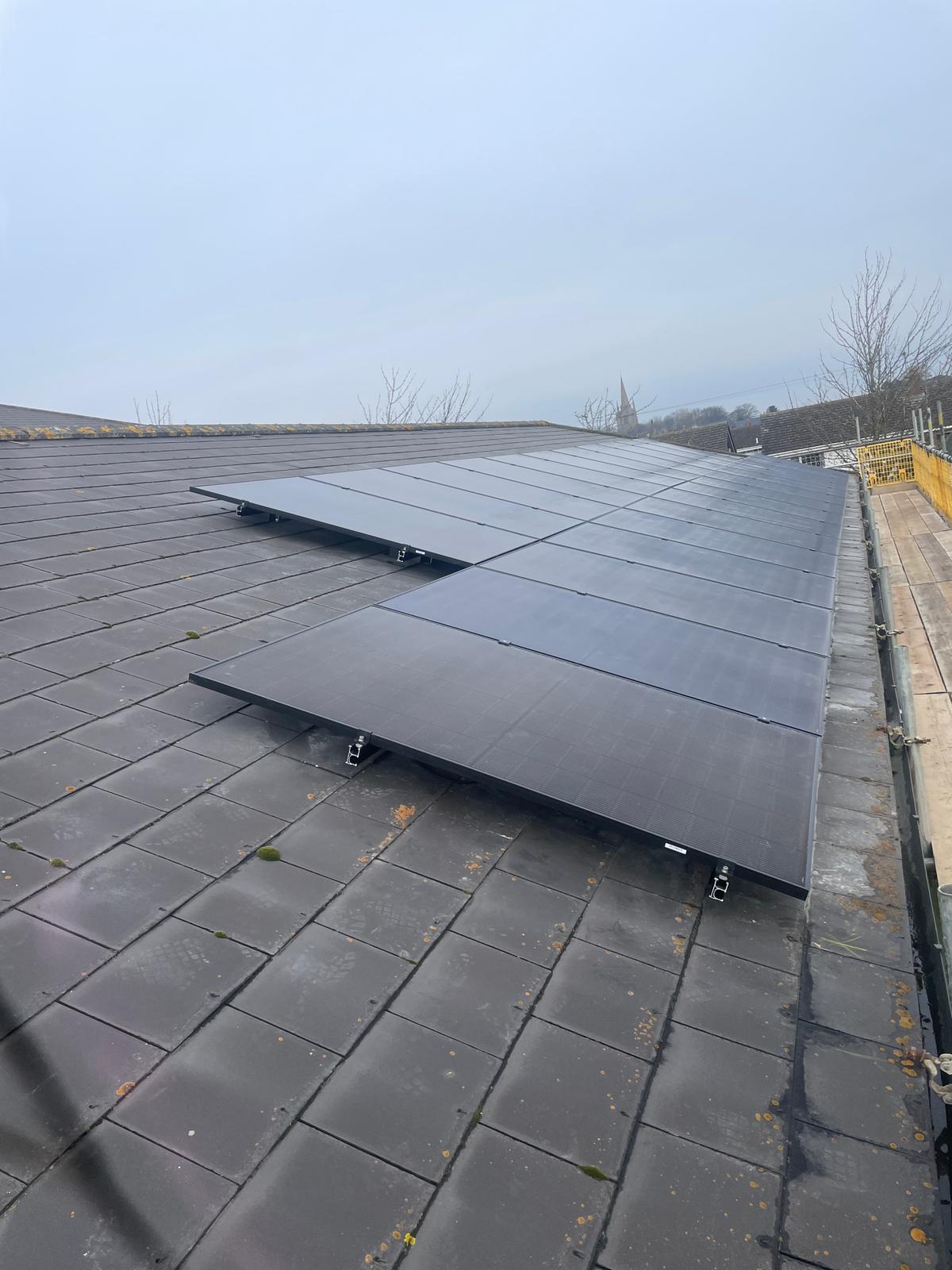 Commercial solar installer finished roof installation showing premium 440W black bifacial solar panels