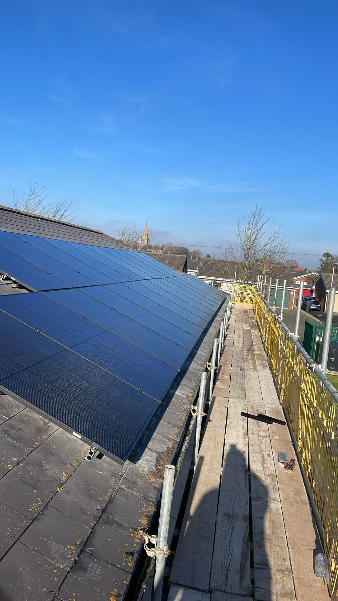 Commercial solar installer fitting 440W bifacial solar panels on medical centre roof