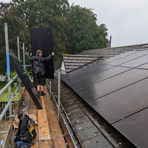 a man in roof installing a solar panel